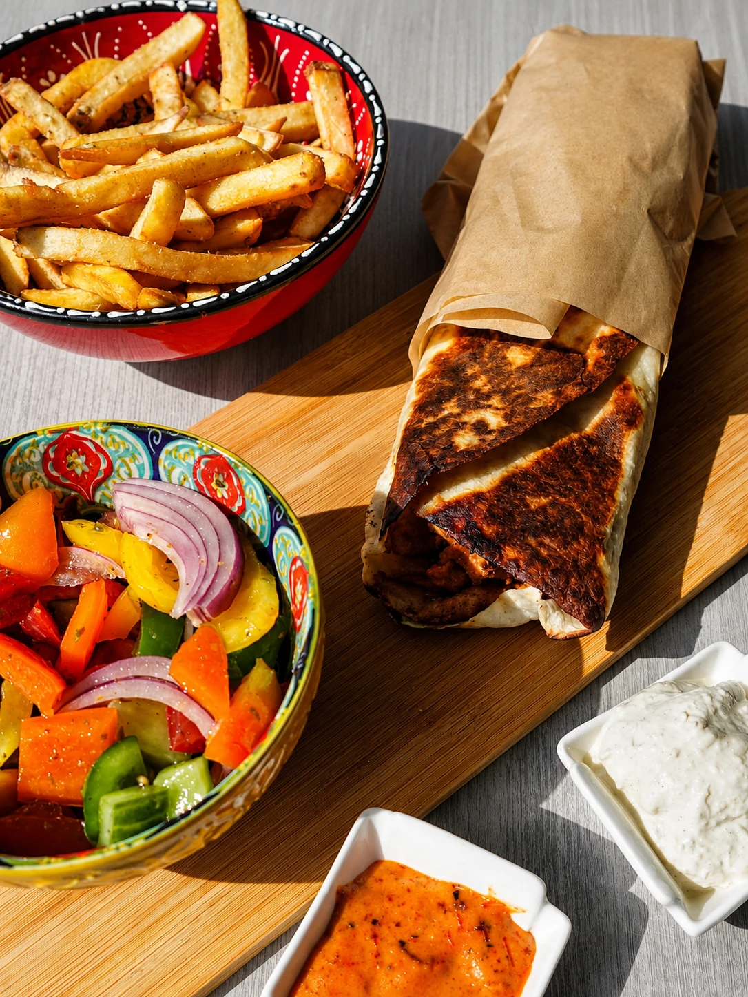 A toasted Middle Eastern wrap served with fries, salad and sauces